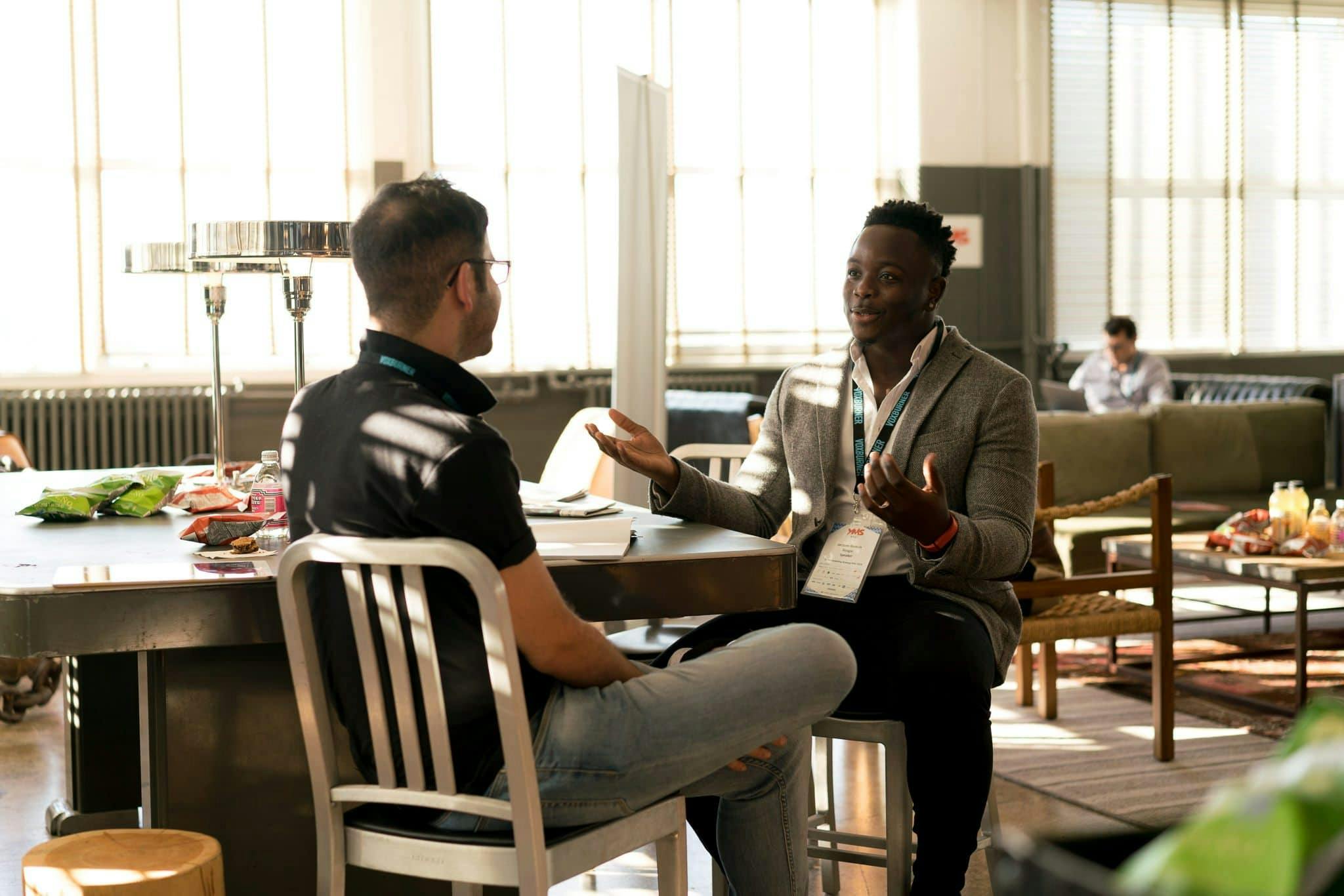 two guys sitting in an office discussing business