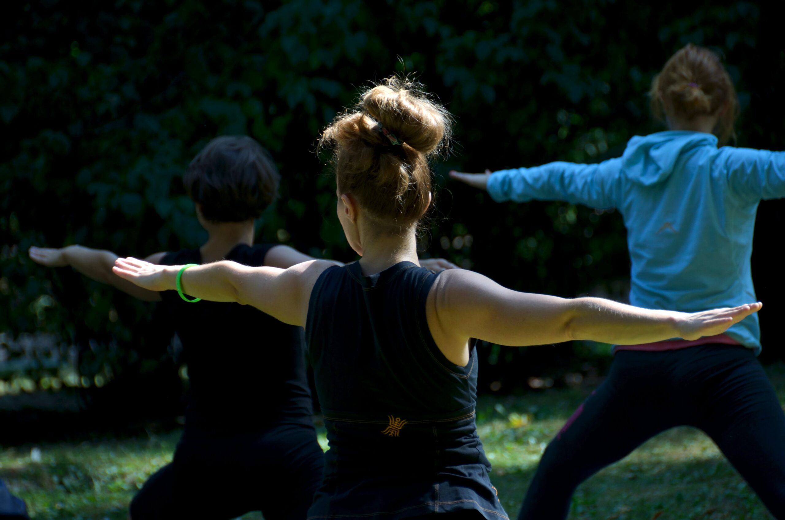 tHE BACK OF A WOMAN WITH HER ARMS OUT IN AN EXERCISE CLASS